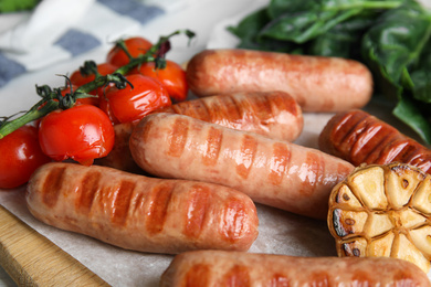 Delicious grilled sausages with vegetables served on table