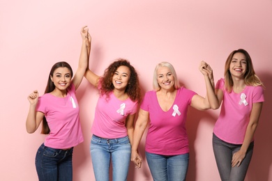Photo of Group of women with silk ribbons on color background. Breast cancer awareness concept