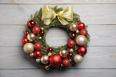 Beautiful Christmas wreath with festive decor on white wooden background