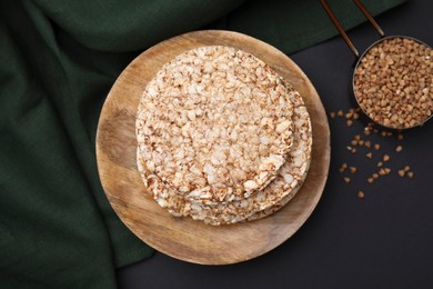 Crunchy buckwheat cakes and cereal on black table, flat lay