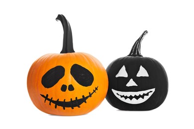 Photo of Halloween pumpkins with scary drawn faces on white background