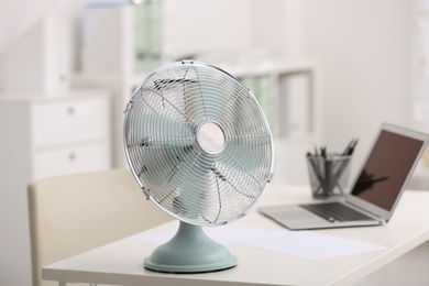 Modern electric fan on table in office