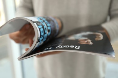 Closeup view of man reading modern magazine