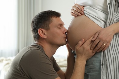 Young pregnant woman with her husband at home, closeup