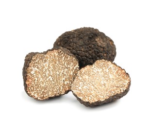 Cut and whole black truffles isolated on white