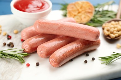 Delicious vegetarian sausages with rosemary and pepper on white marble board, closeup