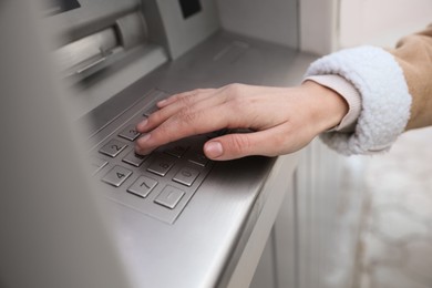Photo of Woman entering cash machine pin code outdoors, closeup