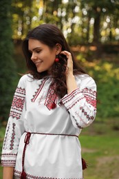 Beautiful woman in embroidered shirt outdoors. Ukrainian national clothes