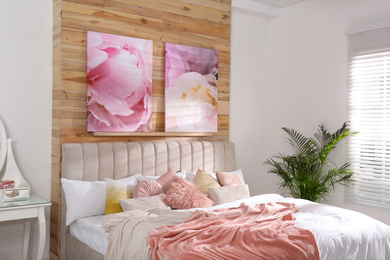 Stylish room interior with large comfortable bed and beautiful paintings