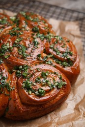 Traditional Ukrainian garlic bread with herbs (Pampushky) on parchment, closeup