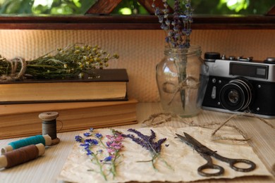 Photo of Composition with beautiful dried flowers and paper on wooden table