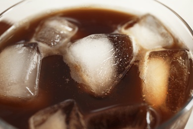 Coffee drink with ice cubes in glass, closeup