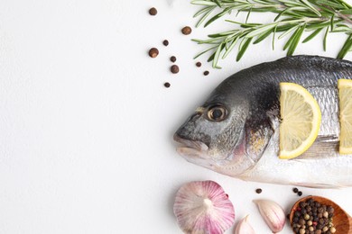 Flat lay composition with fresh raw dorado fish and ingredients on white table, space for text