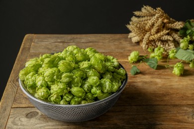 Photo of Fresh green hops and spikes on wooden table