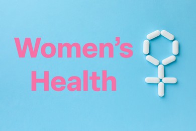 Photo of Words Women's Health and female symbol made of pills on light blue background, flat lay