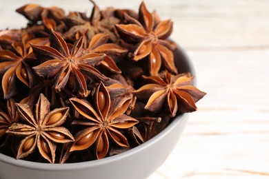 Many aromatic anise stars in bowl, closeup