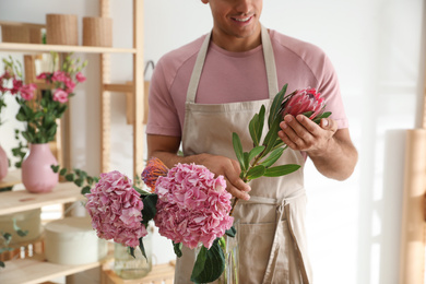 Florist with beautiful flowers in workshop, closeup