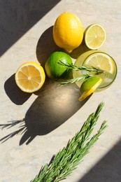 Photo of Summer refreshing lemonade and ingredients on light grey table, flat lay. Space for text