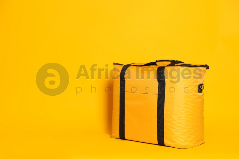 Modern thermo bag on yellow background. Space for text