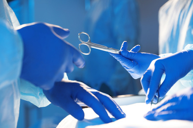Photo of Professional surgeons performing operation in clinic, closeup