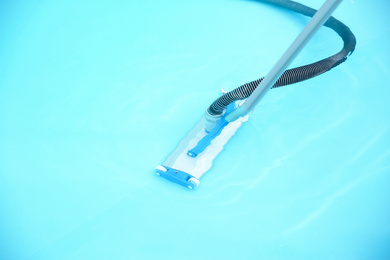 Cleaning outdoor pool with underwater vacuum, closeup