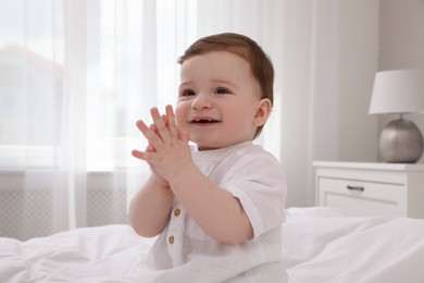 Happy baby boy on bed at home