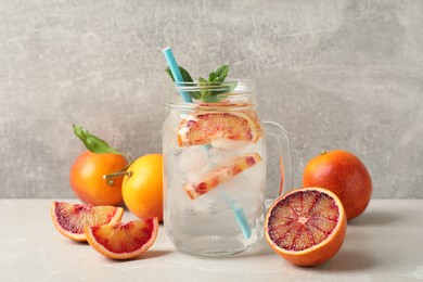 Delicious refreshing drink with sicilian orange and mint on grey table