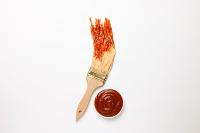 Brush painting with spaghetti dipped in ketchup on white background, top view. Creative concept