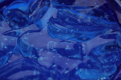Pure transparent cosmetic gel on blue background, closeup