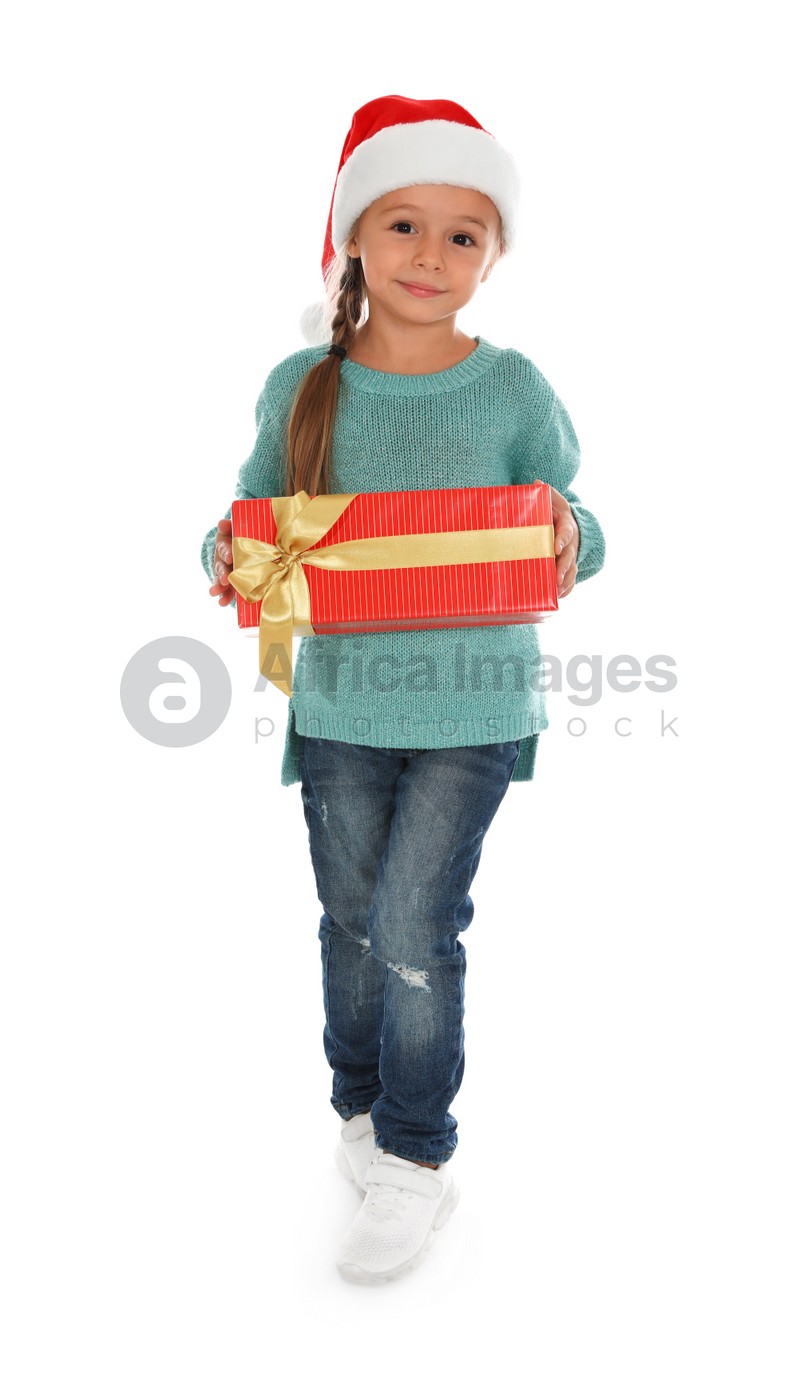Cute little girl in Santa hat with Christmas gift on white background