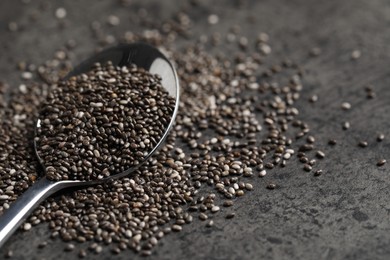 Photo of Spoon with chia seeds on grey table, closeup