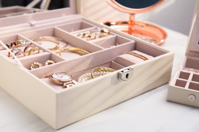 Jewelry box with stylish golden bijouterie on white table