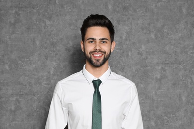 Portrait of confident businessman smiling on grey background