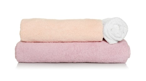 Folded and rolled soft terry towels on white background