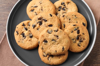 Delicious chocolate chip cookies on wooden table, top view