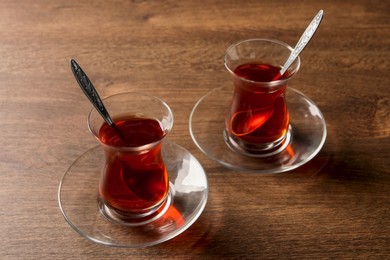 Photo of Glasses of traditional Turkish tea on wooden table