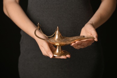 Woman rubbing magical Aladdin lamp, closeup