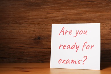 Card with question Are You Ready For Exams? on wooden table. Space for text