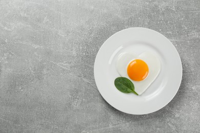 Romantic breakfast with fried egg on light grey table, top view. Space for text