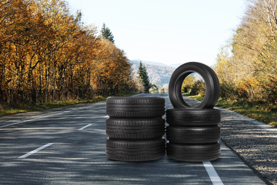 Stacks of car tires on asphalt highway outdoors