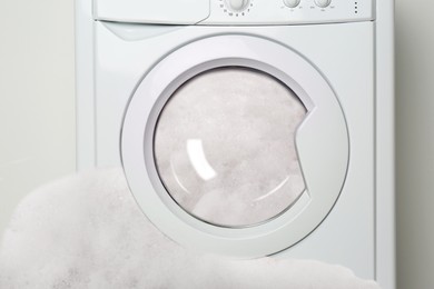 Foam coming out from broken washing machine during laundering