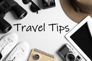 Flat lay composition with tablet, binoculars and camera on white background. Travel Tips