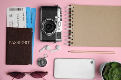 Flat lay composition with passport, tickets and travel items on pink background