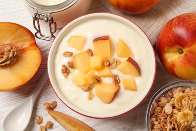 Delicious yogurt with fresh peach and granola on white wooden table, flat lay