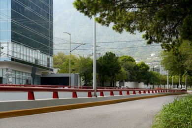 Photo of Modern road with cars in city near mountains