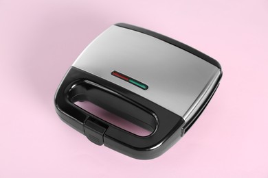 Modern sandwich maker on pink background. Cooking appliance