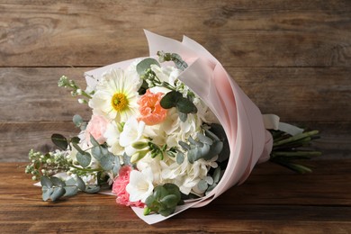 Photo of Bouquet of beautiful flowers on wooden table