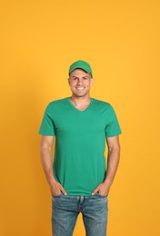 Happy man in green cap and tshirt on yellow background. Mockup for design