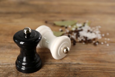 Photo of Salt and pepper shakers on wooden table, closeup. Space for text