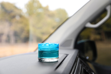 Photo of Stylish air freshener on dashboard in car. Space for text